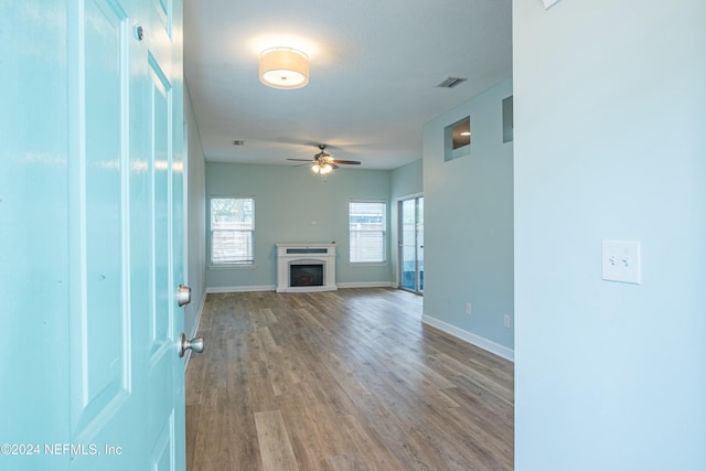 unfurnished living room with ceiling fan and hardwood / wood-style floors