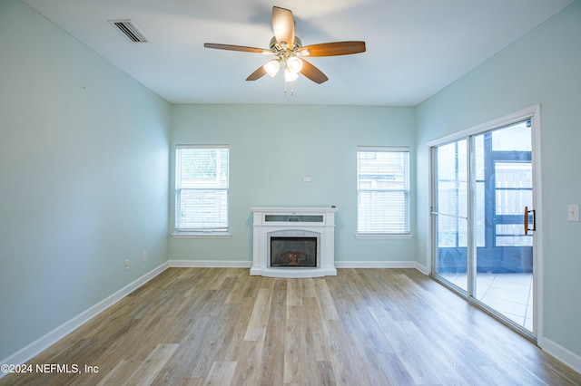 unfurnished living room with light hardwood / wood-style flooring, a wealth of natural light, and ceiling fan