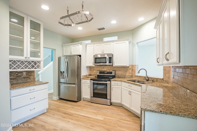 kitchen featuring light wood-type flooring, stainless steel appliances, white cabinetry, and sink