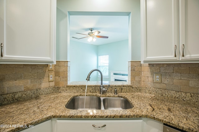 kitchen featuring backsplash, white cabinetry, sink, and light stone counters