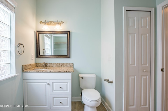 bathroom with hardwood / wood-style floors, vanity, and toilet