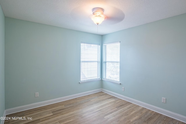 empty room featuring ceiling fan, a textured ceiling, and light hardwood / wood-style flooring