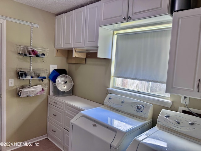 laundry area featuring cabinets, a textured ceiling, and washing machine and dryer