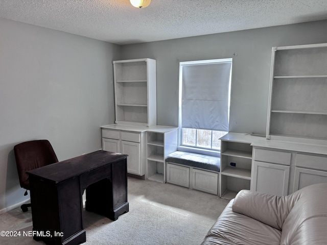 carpeted home office featuring a textured ceiling