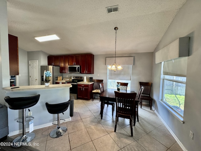 kitchen featuring a chandelier, hanging light fixtures, light tile patterned floors, and stainless steel appliances