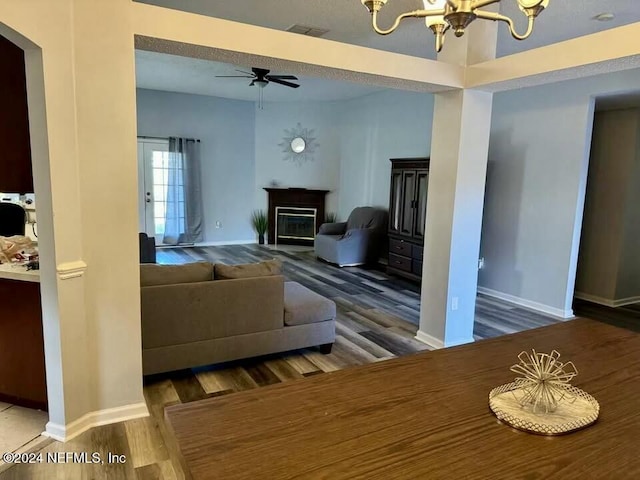 living room featuring hardwood / wood-style floors and ceiling fan with notable chandelier