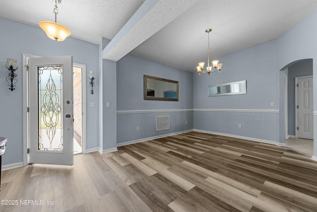3130 Haverhill Ct, Green Cove Springs, FL 32043 - entrance foyer featuring visible vents, a wainscoted wall, wood finished floors, arched walkways, and lofted ceiling