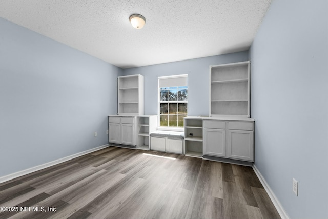 3130 Haverhill Ct, Green Cove Springs, FL 32043 - unfurnished bedroom featuring a textured ceiling, dark wood-type flooring, and baseboards