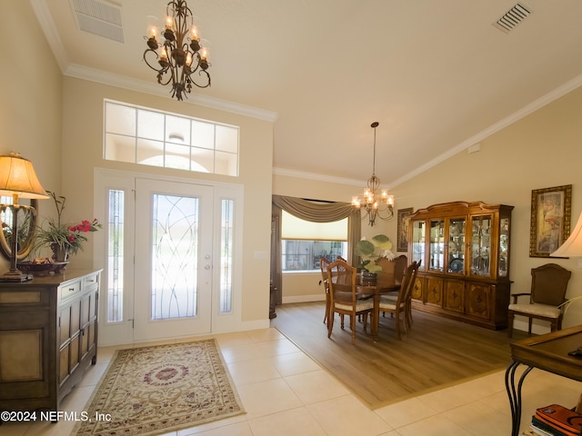 foyer entrance featuring ornamental molding, a notable chandelier, and light wood-type flooring