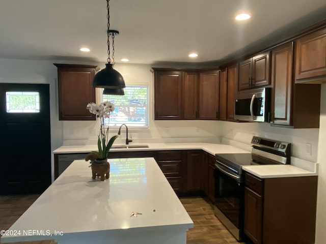 kitchen with sink, hanging light fixtures, dark hardwood / wood-style floors, dark brown cabinets, and appliances with stainless steel finishes