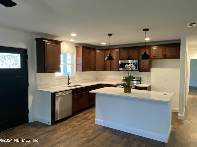 kitchen featuring pendant lighting, a center island, dark hardwood / wood-style flooring, and stainless steel appliances