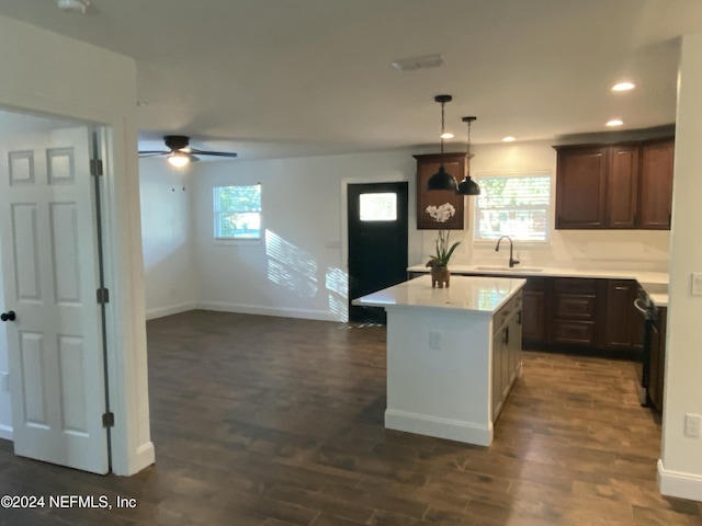 kitchen featuring dark wood-type flooring, a healthy amount of sunlight, sink, and pendant lighting