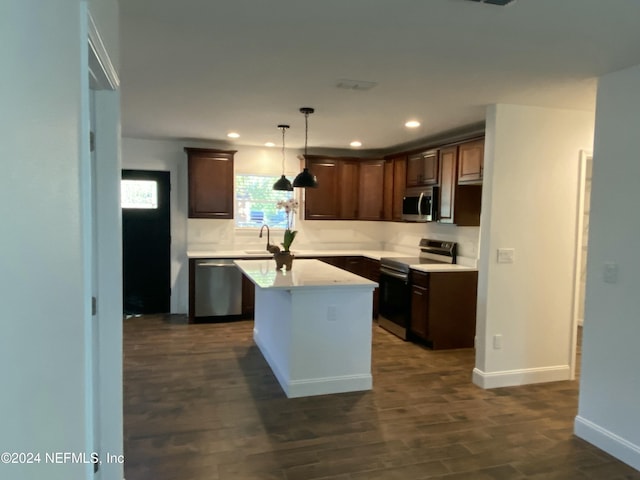 kitchen featuring dark brown cabinetry, hanging light fixtures, dark hardwood / wood-style floors, a kitchen island, and appliances with stainless steel finishes