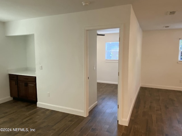 corridor with dark hardwood / wood-style flooring