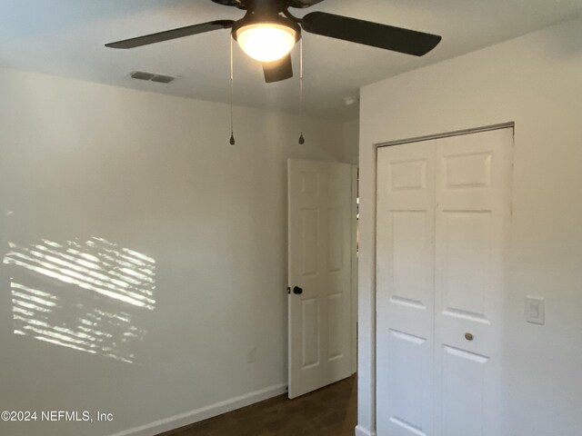 unfurnished bedroom featuring ceiling fan and a closet