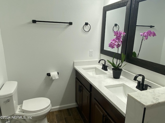 bathroom featuring wood-type flooring, vanity, and toilet