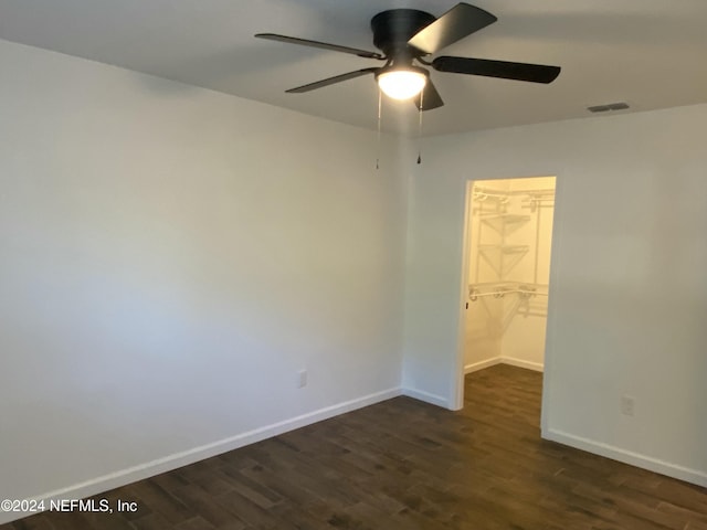 unfurnished room with ceiling fan and dark wood-type flooring