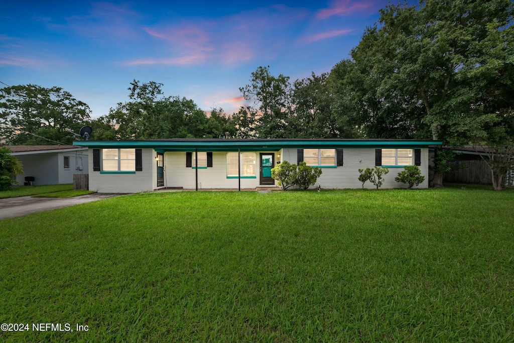 single story home featuring a lawn