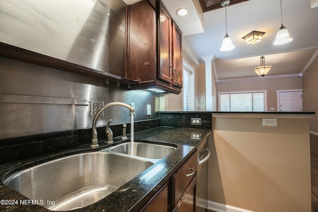 kitchen featuring sink, kitchen peninsula, dark stone countertops, pendant lighting, and ornamental molding