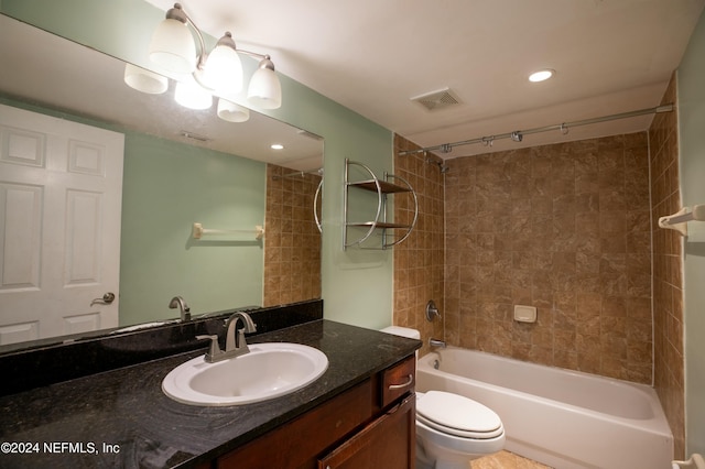 full bathroom featuring vanity, tiled shower / bath combo, and toilet