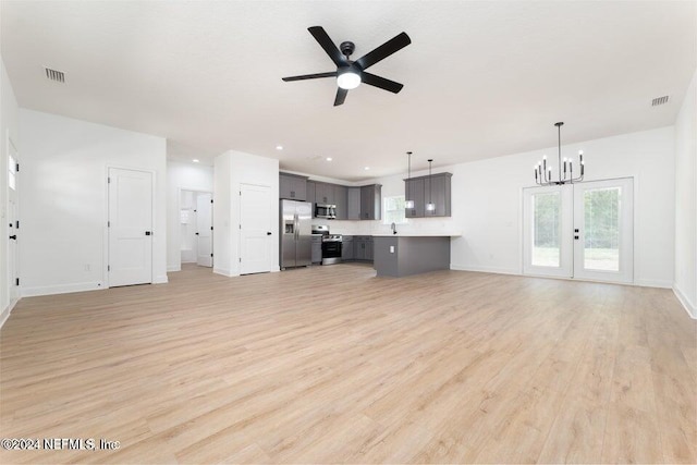 unfurnished living room with ceiling fan with notable chandelier, french doors, light wood-type flooring, and sink