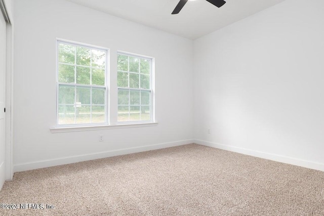 carpeted spare room featuring ceiling fan