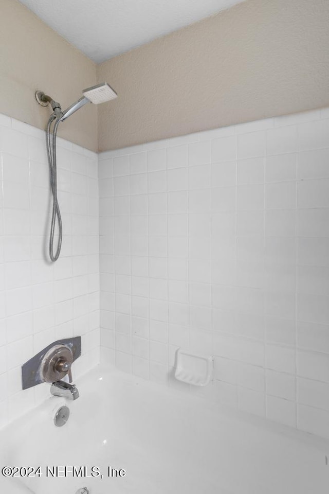 interior space featuring tiled shower / bath combo