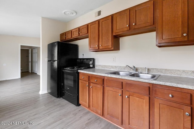 kitchen featuring light hardwood / wood-style flooring, black appliances, and sink