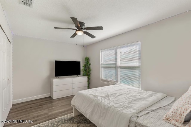 bedroom with ceiling fan, a closet, and wood-type flooring