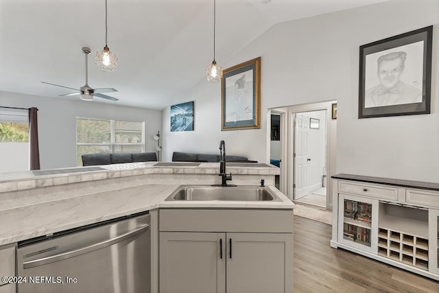 kitchen with light stone counters, dark wood-type flooring, sink, dishwasher, and lofted ceiling