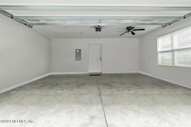 garage featuring ceiling fan, a garage door opener, and electric panel