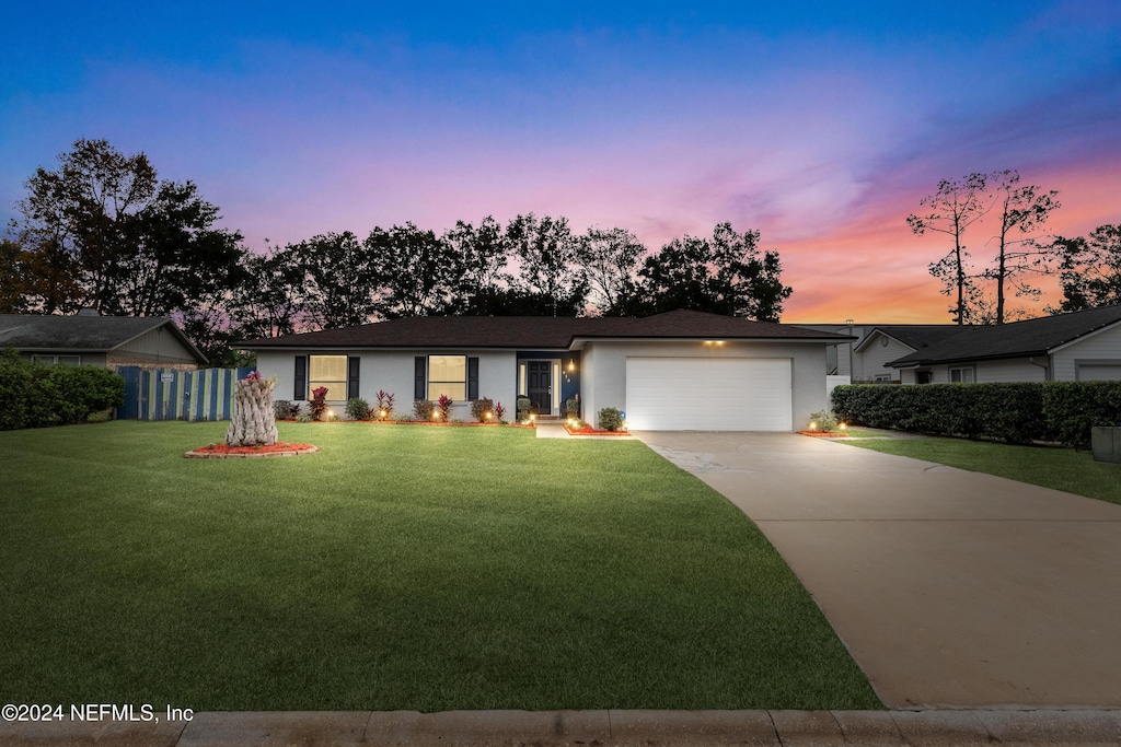 ranch-style house with a lawn and a garage