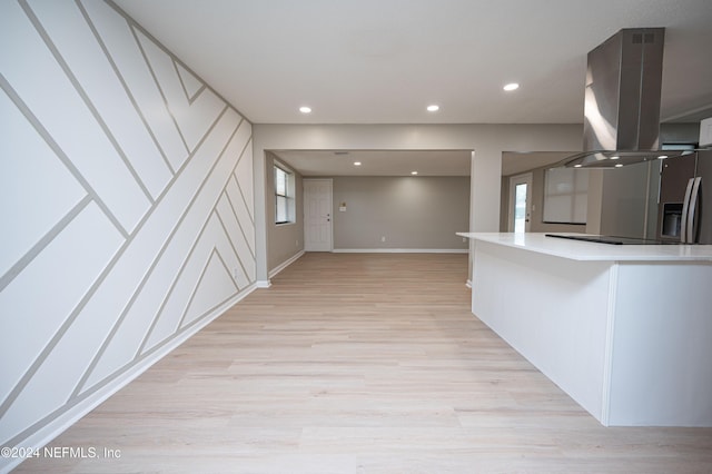 kitchen featuring island exhaust hood, white cabinets, and light wood-type flooring