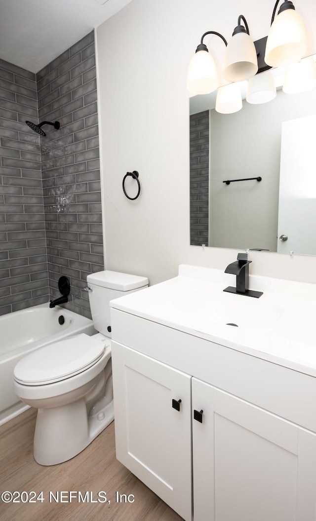 full bathroom with vanity, toilet, tiled shower / bath, and hardwood / wood-style flooring