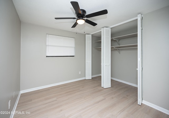 unfurnished bedroom with ceiling fan, light wood-type flooring, and a textured ceiling