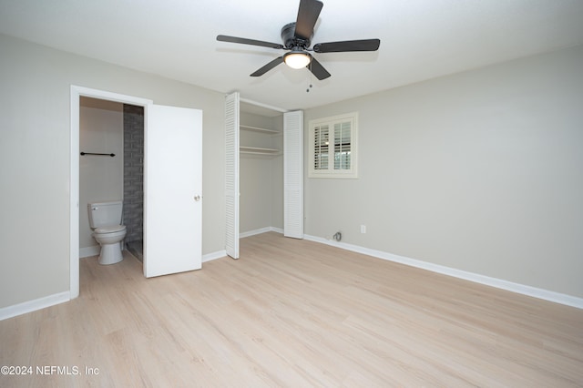 unfurnished bedroom with a closet, light hardwood / wood-style floors, ensuite bath, and ceiling fan