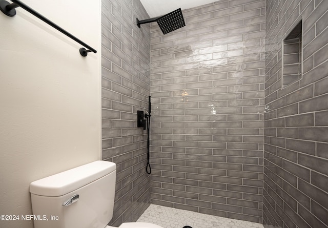 bathroom with toilet and tiled shower