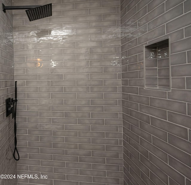 interior details featuring tiled shower