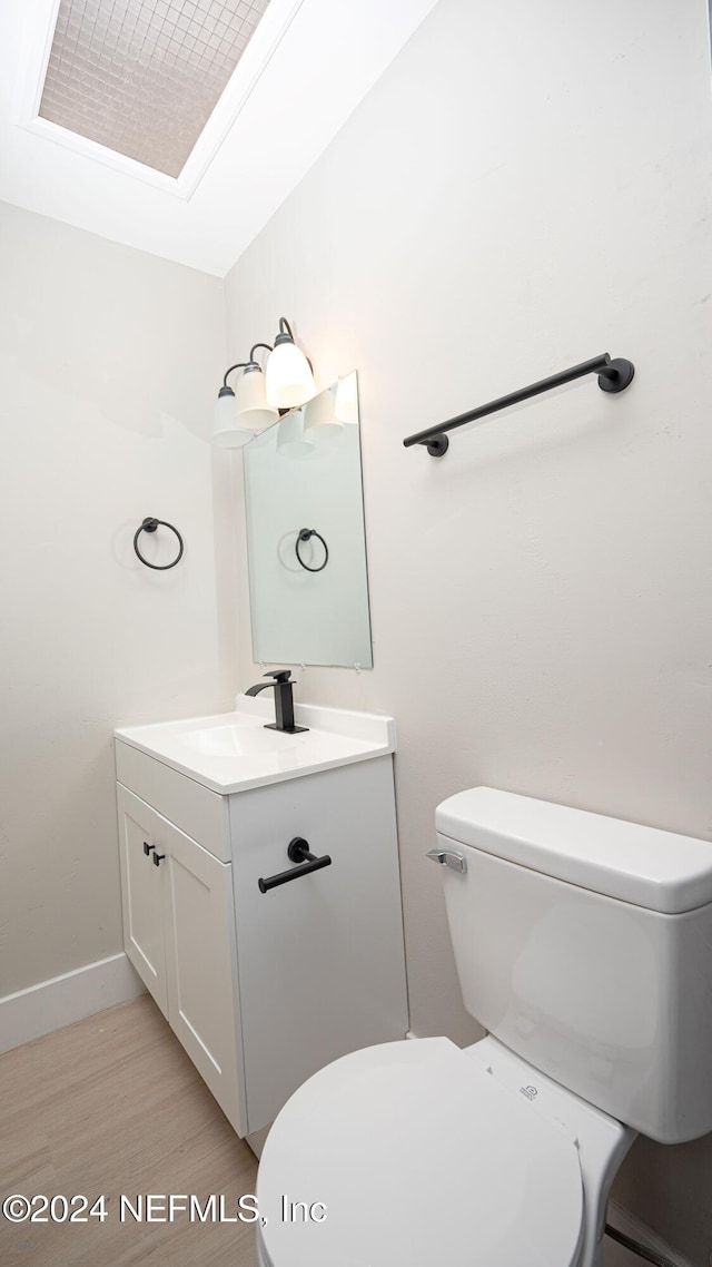 bathroom with hardwood / wood-style floors, vanity, and toilet