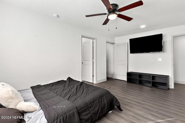 bedroom featuring ceiling fan, hardwood / wood-style floors, and a textured ceiling