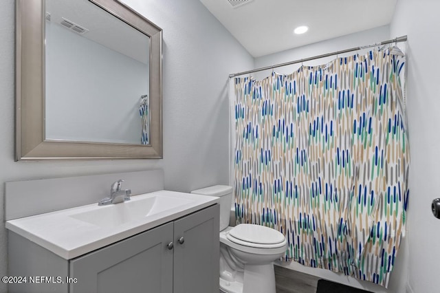 full bathroom with shower / tub combo, vanity, hardwood / wood-style flooring, and toilet