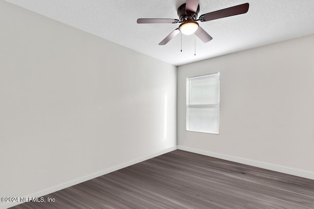 spare room with dark hardwood / wood-style floors, ceiling fan, and a textured ceiling