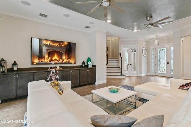 living room featuring crown molding, a fireplace, and light hardwood / wood-style floors