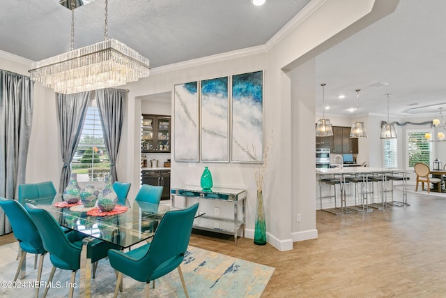 dining room featuring ornamental molding, plenty of natural light, and an inviting chandelier