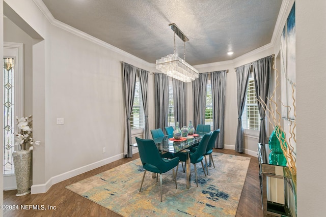 dining area featuring ornamental molding, dark wood-type flooring, a chandelier, and a textured ceiling