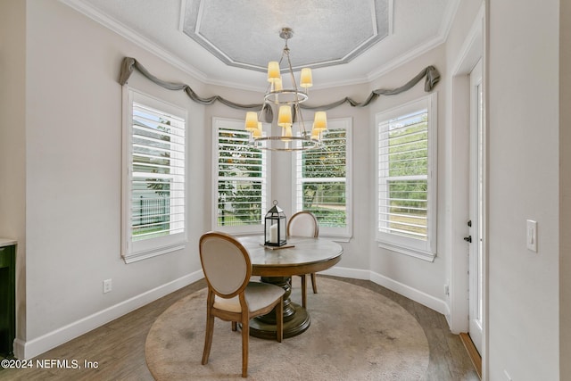 dining space with crown molding, hardwood / wood-style floors, and a notable chandelier