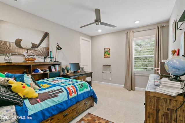 bedroom featuring ceiling fan, light colored carpet, and a textured ceiling