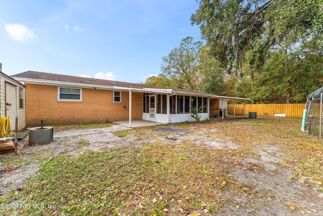 back of property with central AC, a patio area, and a sunroom