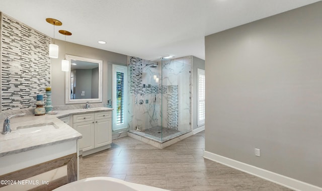 bathroom with vanity, separate shower and tub, and a chandelier