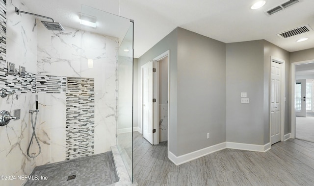 bathroom featuring tiled shower and hardwood / wood-style floors